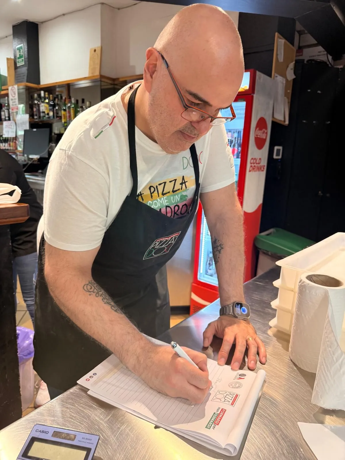 Luiggi tomando notas durante una formación en la Trattoria