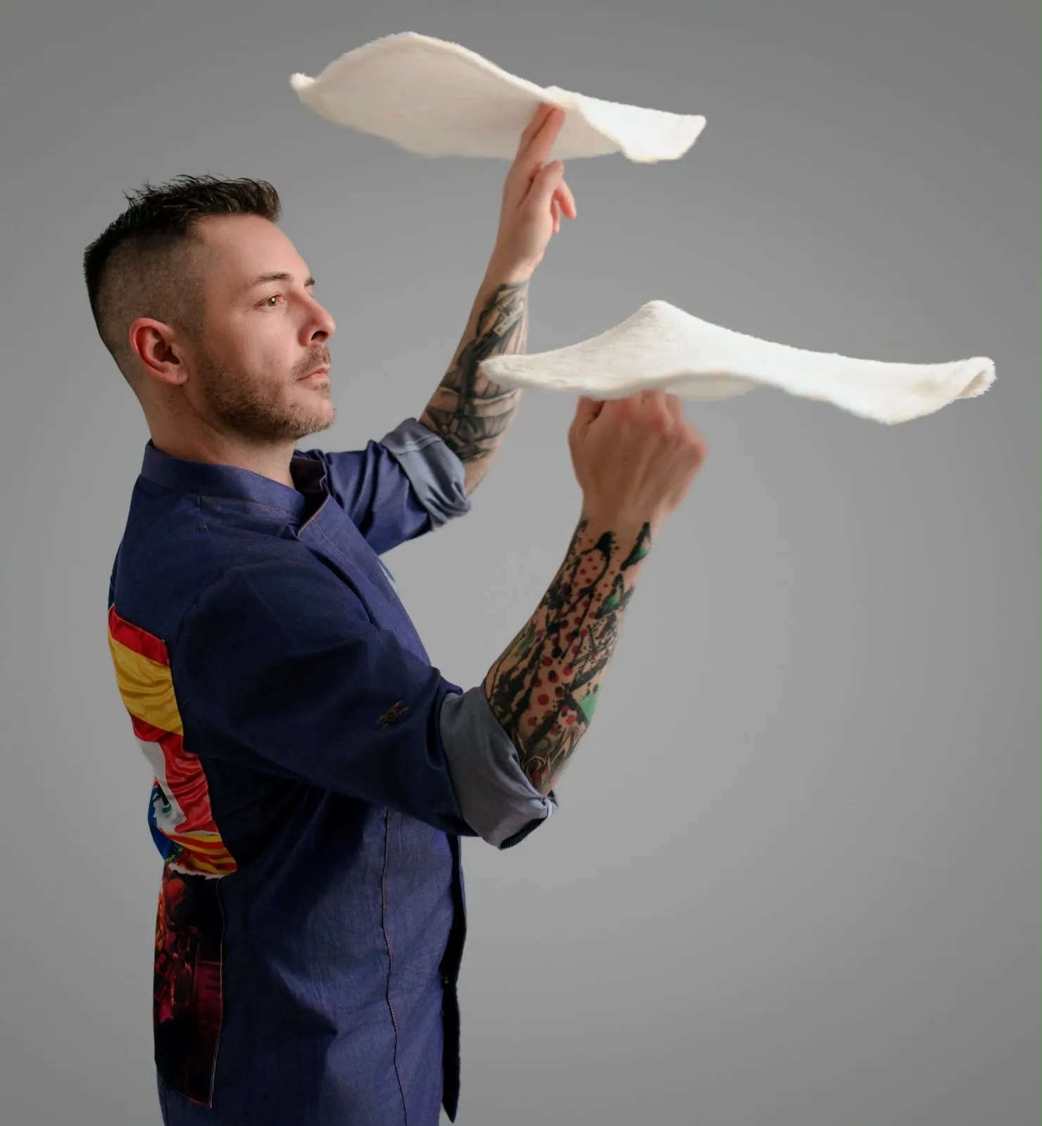 Francis Tolu, pentacampeón de pizza acrobática, haciendo girar dos discos de masa a la vez